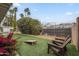 Wide shot of a backyard featuring artificial grass, mature trees, and outdoor seating at 6251 E Hannibal St, Mesa, AZ 85205