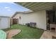 Backyard with artificial grass, a block wall, a shed, and seating at 6251 E Hannibal St, Mesa, AZ 85205