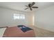 Bright bedroom featuring a ceiling fan, a large window, and carpet flooring at 6251 E Hannibal St, Mesa, AZ 85205
