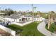 Sprawling estate with lush landscaping, pristine lawn, and long private driveway lined with mature palm trees at 6500 E Cactus Wren Rd, Paradise Valley, AZ 85253