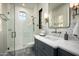 Modern bathroom featuring a glass shower, neutral tile, and a vanity with geometric patterned backsplash at 6500 E Cactus Wren Rd, Paradise Valley, AZ 85253