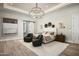 A luxurious bedroom boasts a designer light fixture, stylish decor, comfortable seating and a sliding barn door at 6500 E Cactus Wren Rd, Paradise Valley, AZ 85253