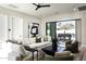 Bright living room with a plush sectional sofa, modern art, access to the backyard, and green accent chairs at 6500 E Cactus Wren Rd, Paradise Valley, AZ 85253