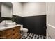 Classic powder room features wood paneled walls, unique tile floors, marble countertop, designer fixtures, and an oval mirror at 6500 E Cactus Wren Rd, Paradise Valley, AZ 85253