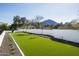 Expansive backyard with lush artificial turf, clean white fencing, and beautiful mountain views at 6500 E Cactus Wren Rd, Paradise Valley, AZ 85253