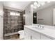 Bathroom features a walk-in shower, white vanity and modern fixtures at 6817 W Palm Ln, Phoenix, AZ 85035