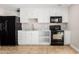 Modern kitchen features white cabinets and black appliances at 6817 W Palm Ln, Phoenix, AZ 85035