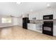 Open layout showcases the kitchen with white cabinetry and black appliances at 6817 W Palm Ln, Phoenix, AZ 85035