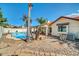 Rear view of home with a covered patio, sparkling pool, and mature palm trees at 7102 W Julie Dr, Glendale, AZ 85308