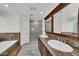 Primary bathroom featuring granite counters, double sinks, vanity, and a glass enclosed shower at 7102 W Julie Dr, Glendale, AZ 85308