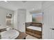 Bright bathroom featuring a drop-in tub with tile surround and double sinks with granite counters at 7102 W Julie Dr, Glendale, AZ 85308