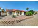 Front exterior showcasing desert landscaping, solar panels, and a low-maintenance yard at 7102 W Julie Dr, Glendale, AZ 85308