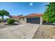 View of the home's front exterior featuring a two-car garage and desert landscaping at 7102 W Julie Dr, Glendale, AZ 85308