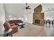 Spacious living room with a stone fireplace, carpet flooring, and lots of natural light at 7102 W Julie Dr, Glendale, AZ 85308