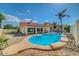 Backyard view of pool and covered patio with lush landscaping on a sunny day at 7102 W Julie Dr, Glendale, AZ 85308