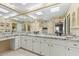 Elegant bathroom showcasing dual sinks with granite countertops, white cabinets, and ample mirror space at 7121 E Mcdonald Dr, Paradise Valley, AZ 85253