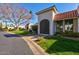 Beautiful home exterior with arched gate, lush landscaping, and charming tile roof at 7121 E Mcdonald Dr, Paradise Valley, AZ 85253