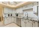 Well-lit kitchen featuring modern appliances, granite countertops, and white cabinets with ample storage space at 7121 E Mcdonald Dr, Paradise Valley, AZ 85253