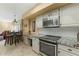 Stylish kitchen featuring stainless steel appliances, granite countertops, and white cabinetry with tiled backsplash at 7121 E Mcdonald Dr, Paradise Valley, AZ 85253