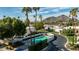 Beautiful in-ground community pool surrounded by palm trees, with views of the mountain in the distance at 7121 E Mcdonald Dr, Paradise Valley, AZ 85253
