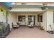 Cozy backyard patio space with brick pavers, neutral outdoor seating and string lights at 714 W Desert Hills Dr, San Tan Valley, AZ 85143