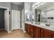 Bright bathroom featuring double sinks, white cabinets, tile floors and a shower at 714 W Desert Hills Dr, San Tan Valley, AZ 85143