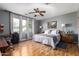Cozy bedroom with wood floors, a comfortable queen-size bed, two bedside tables, and ample natural light at 714 W Desert Hills Dr, San Tan Valley, AZ 85143