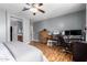 Bedroom featuring ceiling fan, hardwood floors, work area, and ensuite bathroom at 714 W Desert Hills Dr, San Tan Valley, AZ 85143