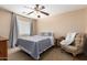 Comfortable bedroom with a queen bed, ceiling fan, and warm, inviting decor at 714 W Desert Hills Dr, San Tan Valley, AZ 85143
