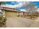 Charming two-story home with tan stucco, a tile roof, three-car garage and manicured landscaping at 714 W Desert Hills Dr, San Tan Valley, AZ 85143