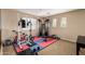 Spacious home gym area featuring workout equipment, weights, and natural light at 714 W Desert Hills Dr, San Tan Valley, AZ 85143