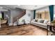 Comfortable living room with hardwood floors, stairs, and natural light from the window at 714 W Desert Hills Dr, San Tan Valley, AZ 85143