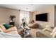 Cozy living room featuring neutral walls, plush seating, a large television, and natural light at 714 W Desert Hills Dr, San Tan Valley, AZ 85143