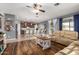 Open-concept living space with hardwood floors, a comfortable sofa, and an adjacent kitchen area at 714 W Desert Hills Dr, San Tan Valley, AZ 85143