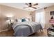 Inviting main bedroom features a ceiling fan, soft gray bedding, and bright, natural light at 714 W Desert Hills Dr, San Tan Valley, AZ 85143