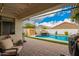 A covered patio overlooks the pool, ideal for outdoor entertaining and relaxation at 714 W Desert Hills Dr, San Tan Valley, AZ 85143