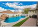 A rock waterfall feature adds a touch of nature to the backyard pool and patio area at 714 W Desert Hills Dr, San Tan Valley, AZ 85143