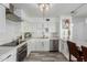 Well-lit kitchen with white cabinetry, modern fixtures, and stainless steel appliances at 7751 E Glenrosa Ave # A1, Scottsdale, AZ 85251