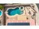 Aerial view of a backyard oasis featuring a lagoon pool, hot tub, covered patio, and lush desert landscaping at 8335 W Berridge Ln, Glendale, AZ 85305