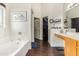 Bright bathroom with a soaking tub, white tiled backsplash, and a view of the walk-in closet at 8335 W Berridge Ln, Glendale, AZ 85305