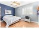 This light and airy bedroom features laminate floors, ceiling fan, blue accent wall, and plantation shutters at 8335 W Berridge Ln, Glendale, AZ 85305