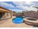 Inviting backyard oasis featuring a sparkling pool, hot tub, and stone patio perfect for relaxation at 8335 W Berridge Ln, Glendale, AZ 85305