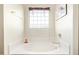 Soaking tub with privacy glass block window provides a spa-like atmosphere at 8335 W Berridge Ln, Glendale, AZ 85305