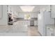 Bright kitchen features white cabinetry, stainless steel appliances, and a skylight for natural light at 8476 E Wethersfield Rd, Scottsdale, AZ 85260