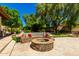 Inviting backyard with stone fire pit, ample seating and mature trees, perfect for outdoor gatherings and relaxation at 8649 S Willow Dr, Tempe, AZ 85284