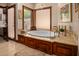 Luxurious bathroom featuring an oval bathtub with rich wood cabinetry and a view from the window at 8649 S Willow Dr, Tempe, AZ 85284