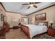 Cozy bedroom featuring hardwood floors, a ceiling fan, and complemented by a classic, comfy bed at 8649 S Willow Dr, Tempe, AZ 85284
