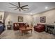 Comfortable living room featuring a large ceiling fan, leather furniture, and versatile open space at 8649 S Willow Dr, Tempe, AZ 85284