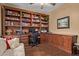 Home office with hardwood floors, built-in desk, shelving, and a comfortable sofa at 8649 S Willow Dr, Tempe, AZ 85284