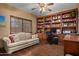 Inviting home office with built-in bookshelves, hardwood floors, and comfortable seating at 8649 S Willow Dr, Tempe, AZ 85284